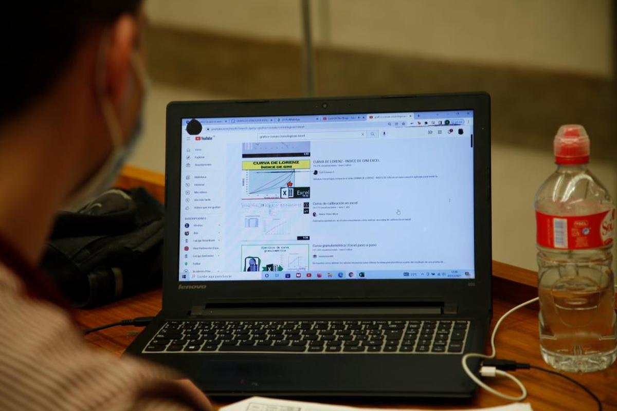 Un joven consultando internet en su portátil.