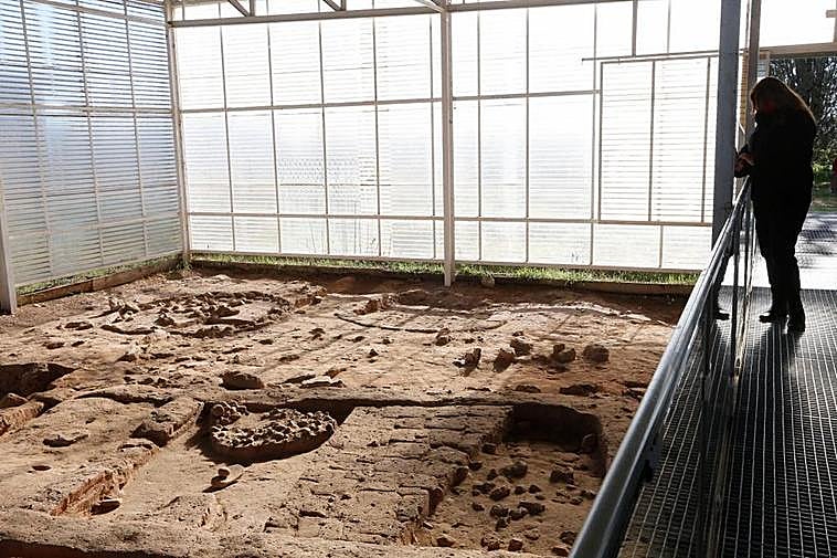 Una visitante contempla parte de los restos de la Edad de Hierro.