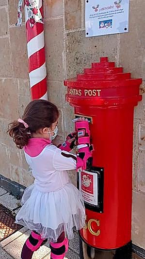 Una niña introduce su carta para Papá Noel en el buzón de Santi