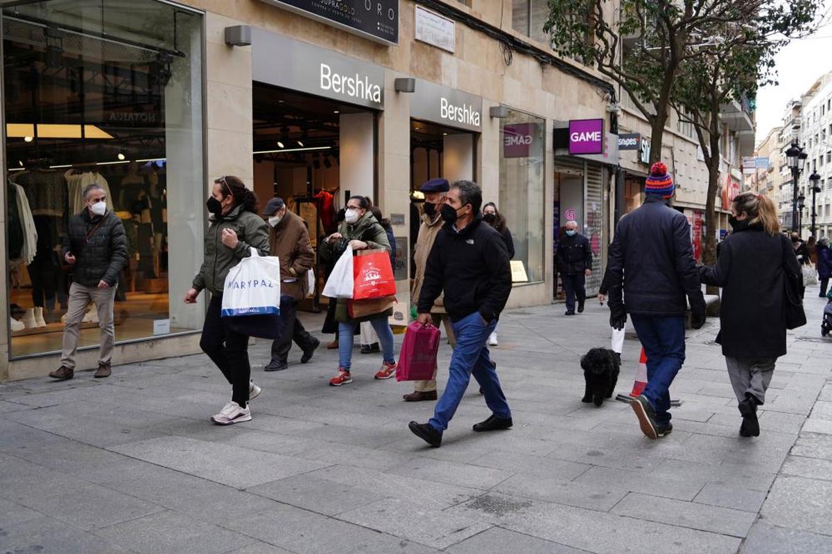 Varias personas en la calle Toro con bolsas de compras.