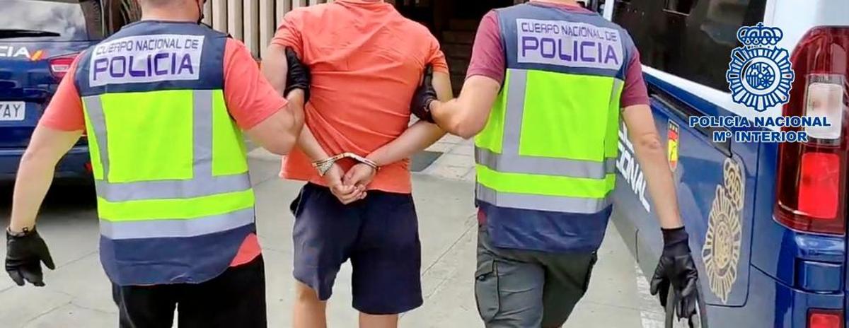 Dos agentes de la Policía Nacional trasladan a un detenido