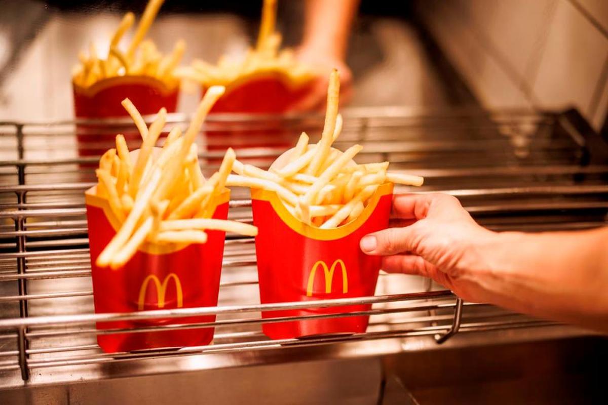 El trabajador muestra cómo cocinan las patatas fritas