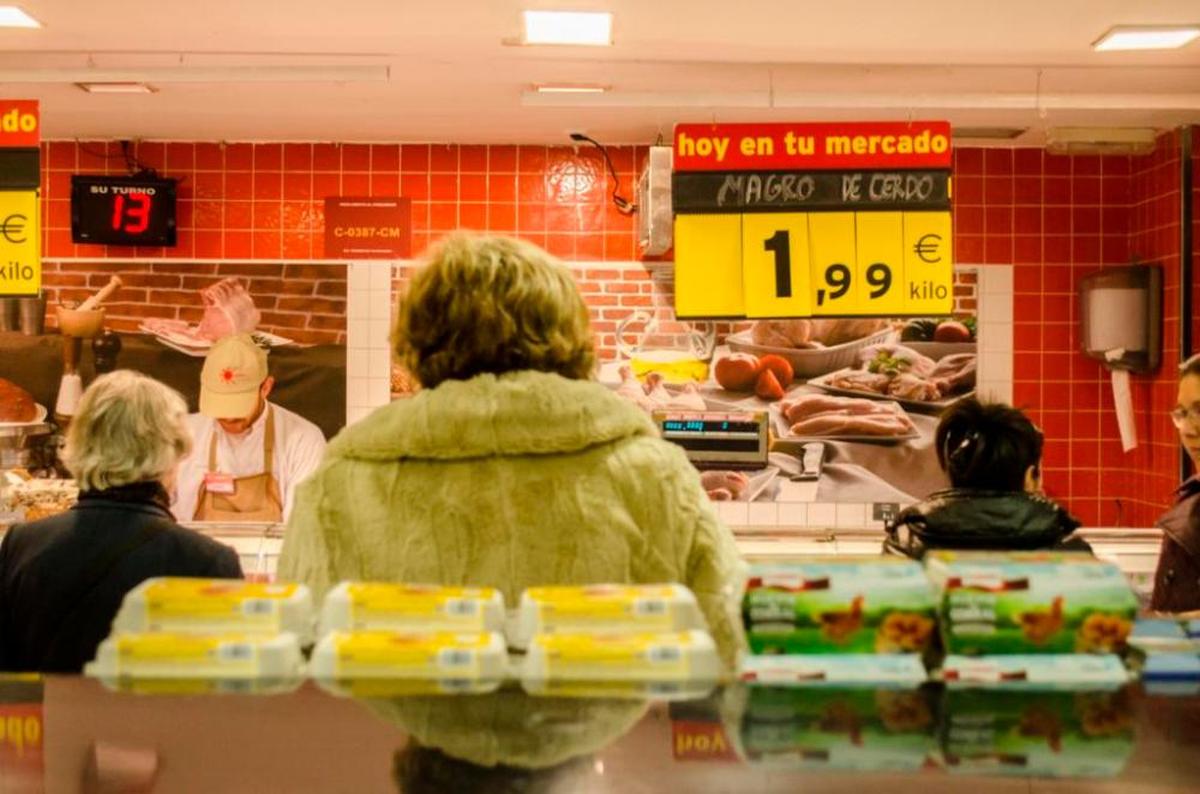 Varias personas comprando en un supermercado.