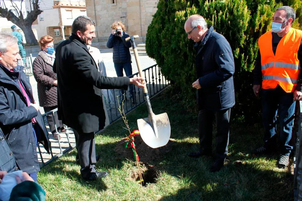 El alcalde de La Fregeneda cede la pala a Javier Iglesias durante la plantación del almendro.