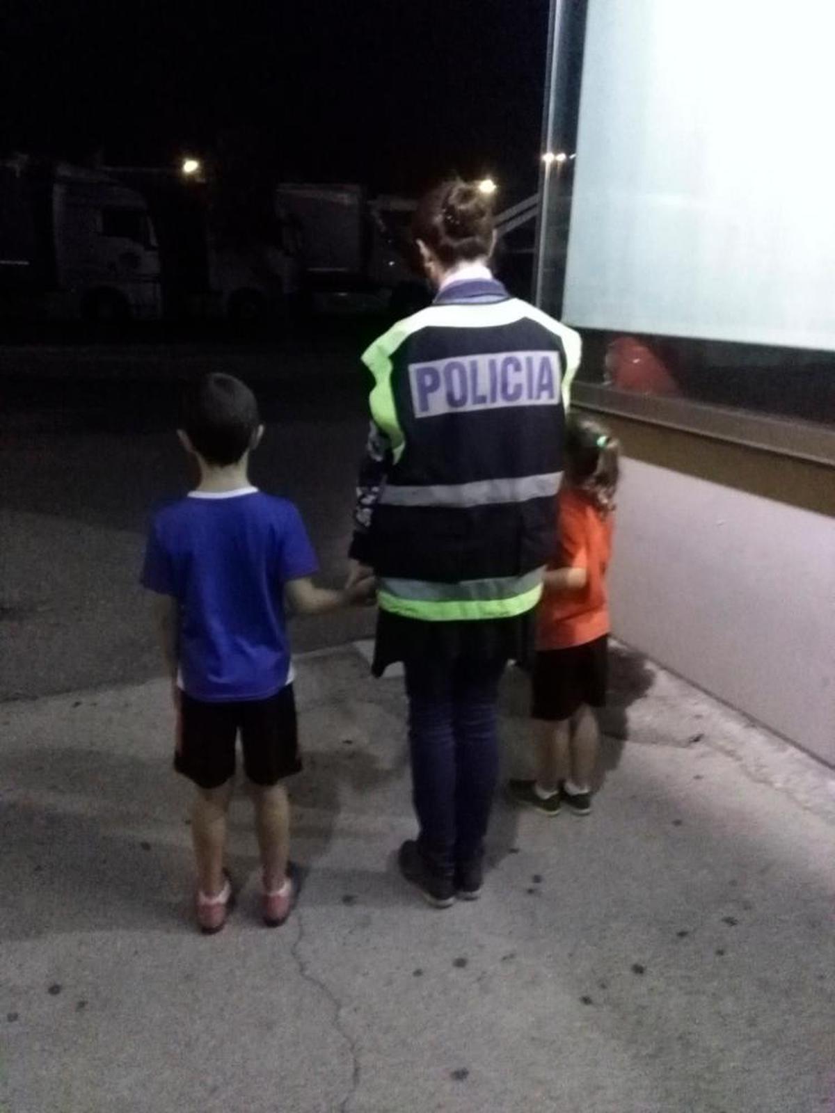 Una policía junto a los dos pequeños tras ser localizados.