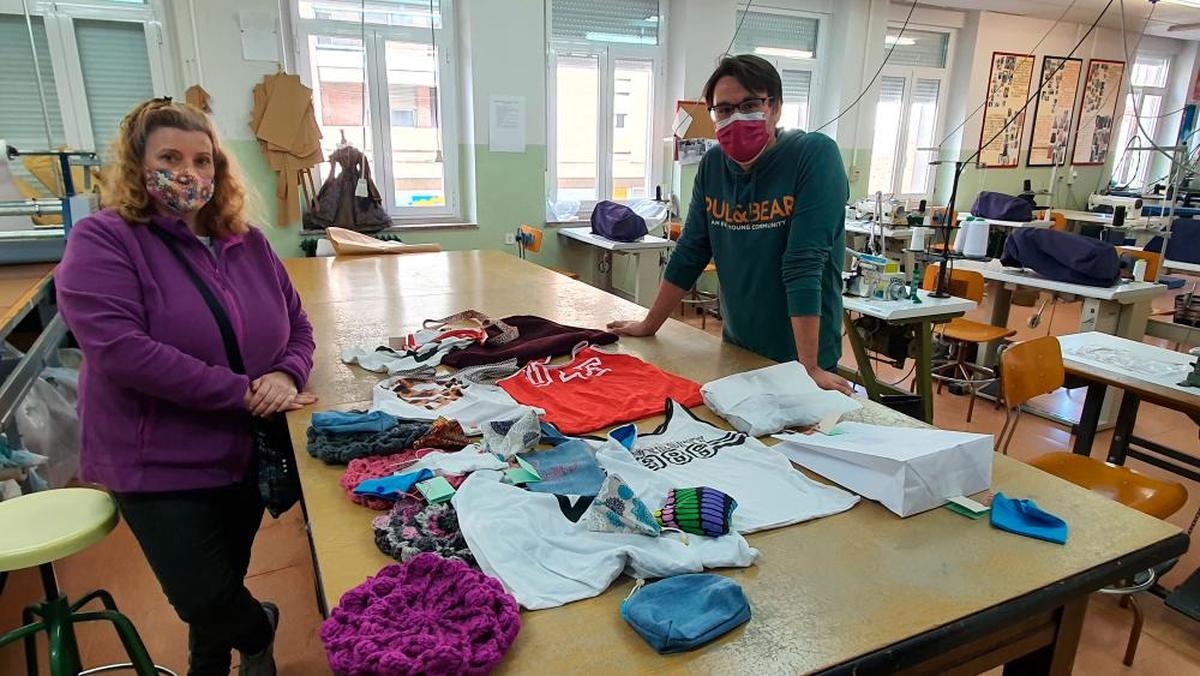 La alumna Ana Cerón y el director del centro, Jorge García, con las prendas recicladas en bolsas y estuches.