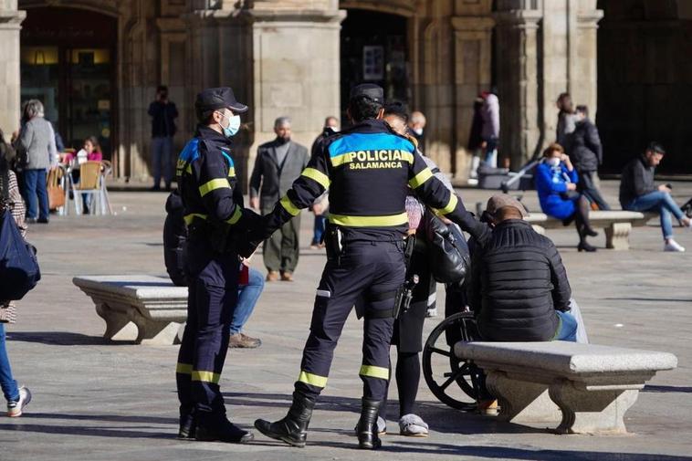 Dos policías locales conversan con una ciudadana en la Plaza Mayor