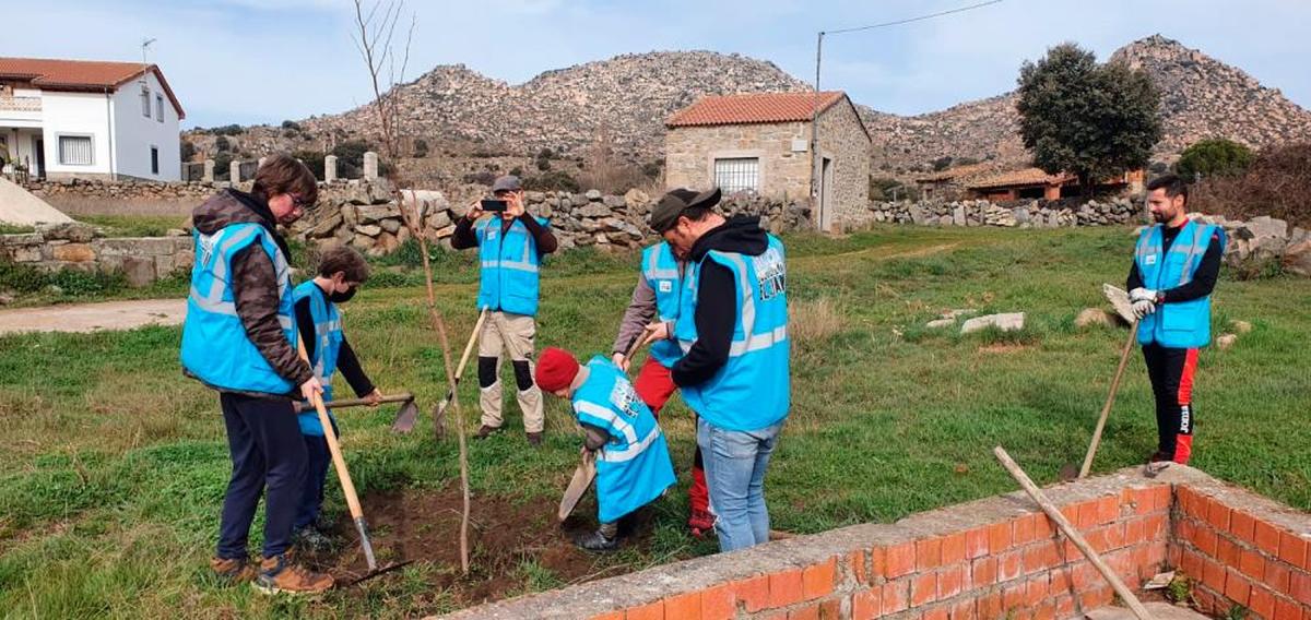 Momento de la plantación de un ejemplar en el núcleo de La Magdalena con El Berrueco al fondo