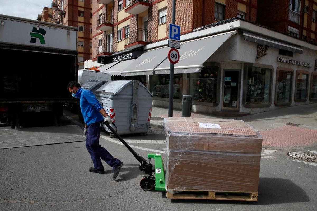 Un operario del transporte arrastra un palé de productos ayer en María Auxiliadora