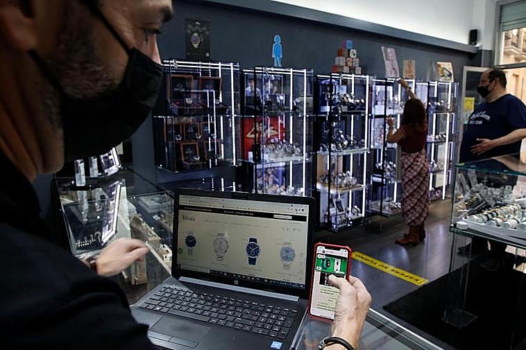 Un comerciante consulta su página web y la aplicación de su tienda.