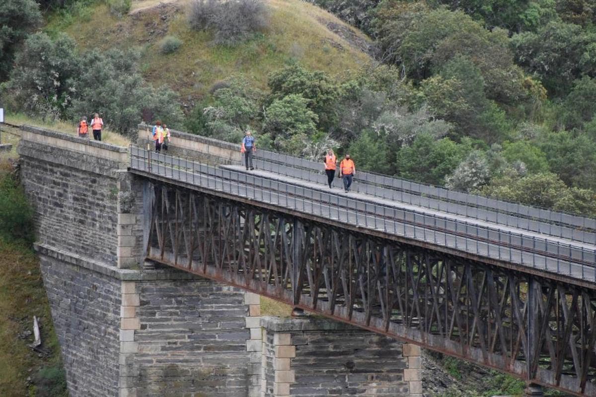 Visitantes del Camino de Hierro cruzando uno de los puentes de la histórica y recuperada vía férrea
