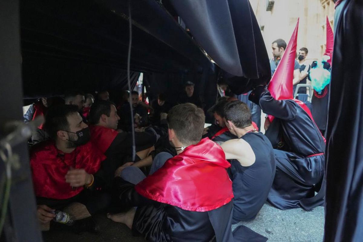 Hermanos de carga del Silencio, exhaustos, en un parón de la procesión del Sábado Santo.