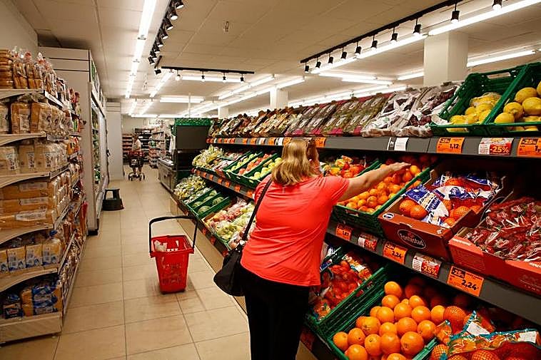 Una mujer coge mandarinas en el lineal de fruta de un supermercado de Salamanca.