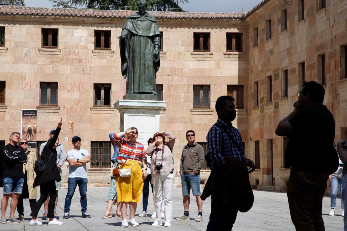 Un grupo de turistas contempla la fachada rica de la Universidad de Salamanca.