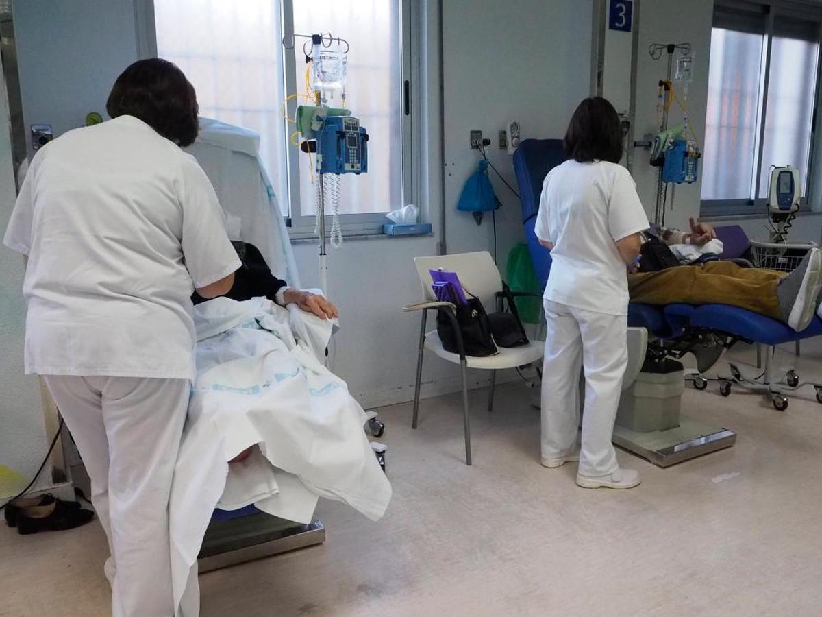 Enfermeras del hospital oncohematológico atienden a dos pacientes durante su tratamiento.