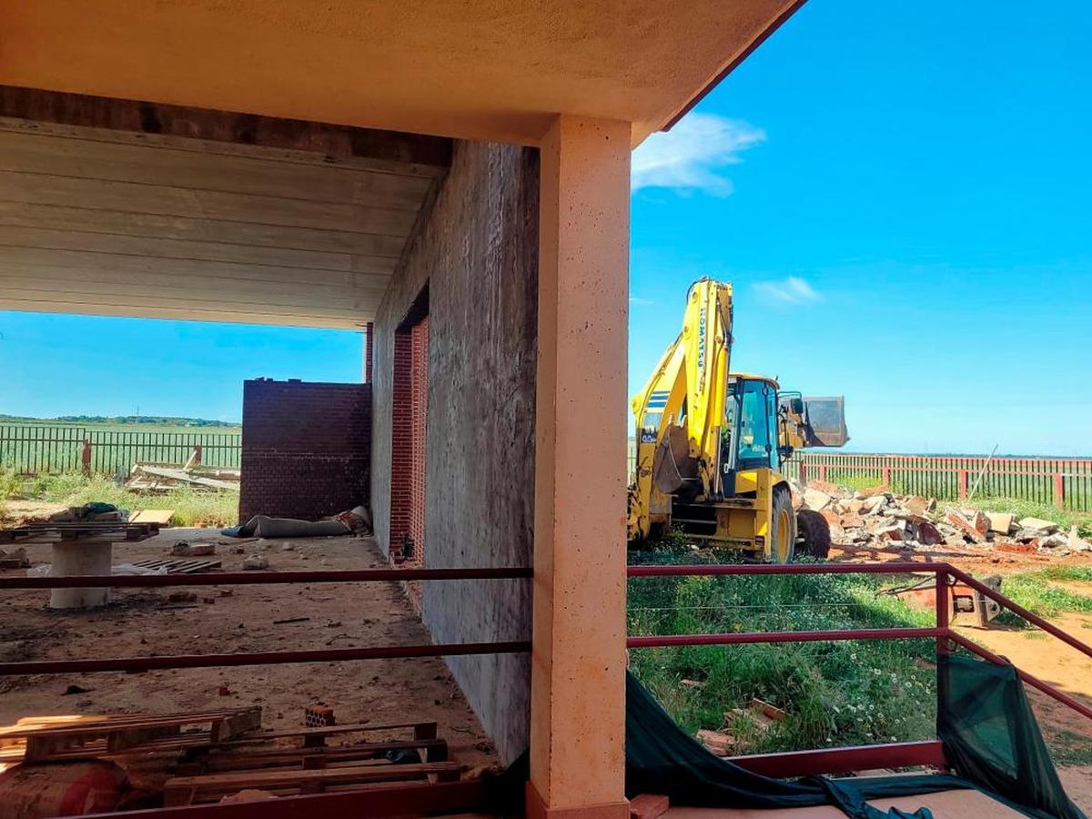 El aula parcialmente construida y la máquina en la zona de la nueva obra.