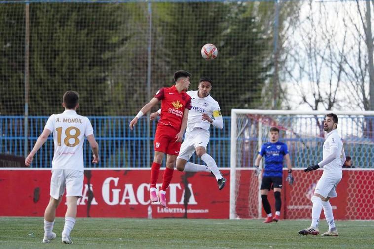 Tomi, de rojo y Dani, de blanco, saltan a por el balón.