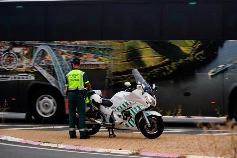 Un efectivo de la Guardia Civil junto a su moto en un control de carretera.