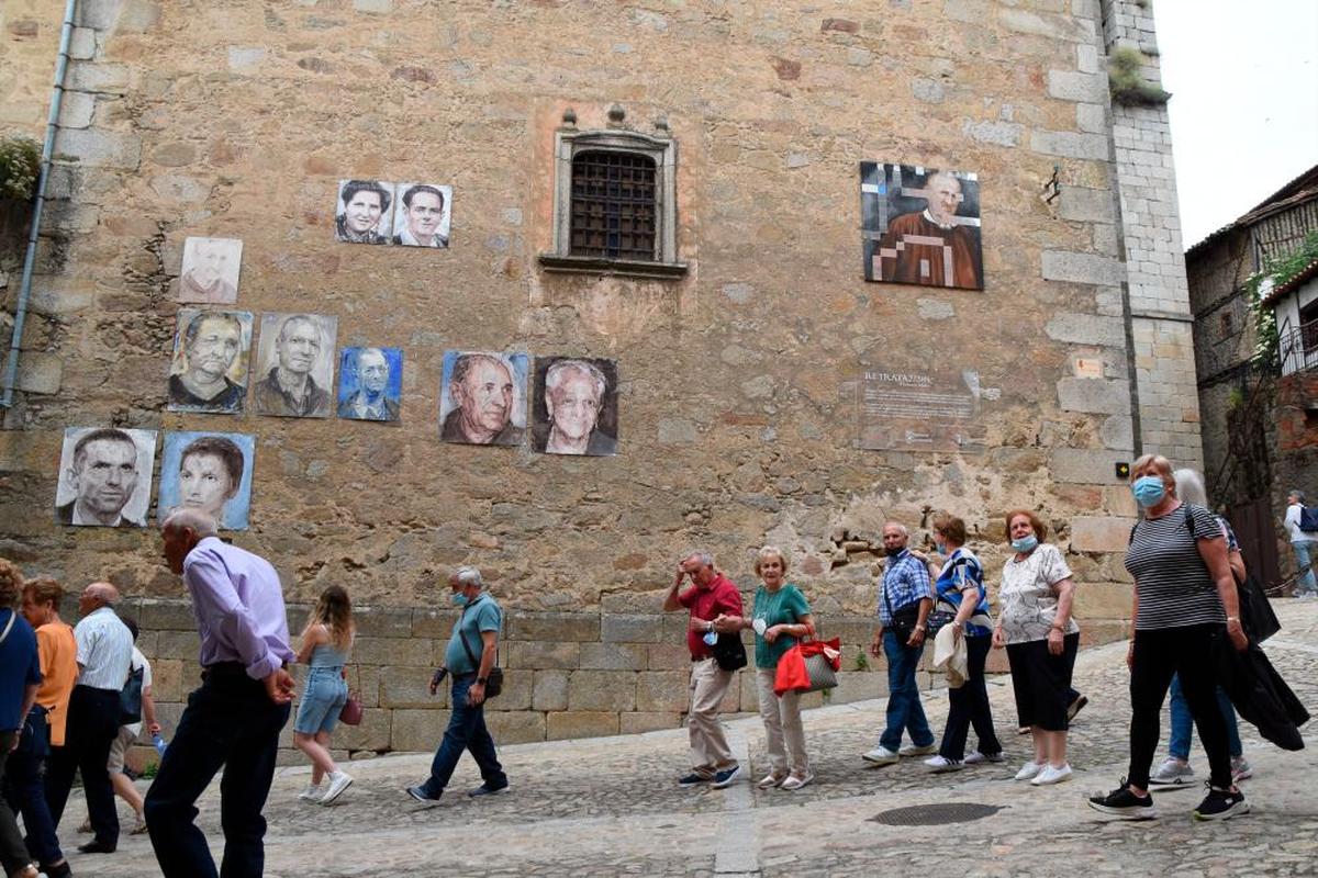 Un grupo de turistas recorre las calles de Mogarraz, que lucen la exposición pictórica ”Retrata2”