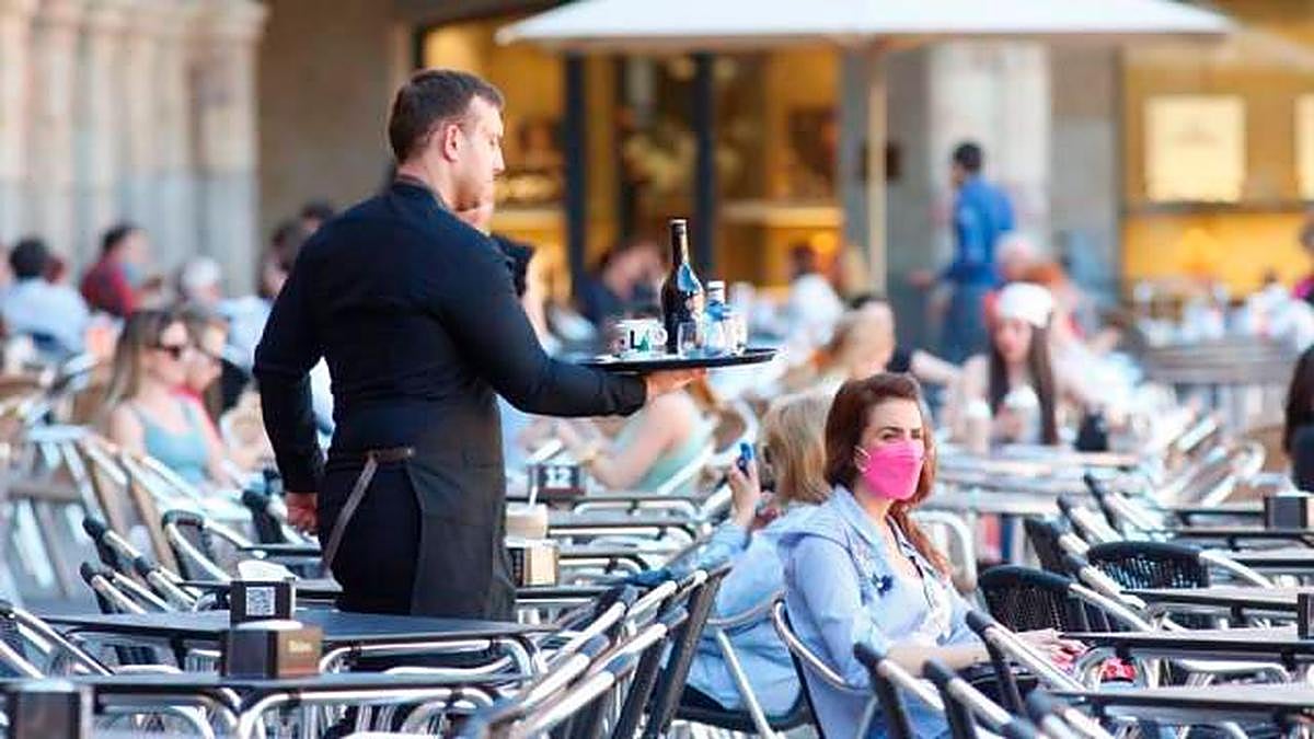 Un camarero sirviendo en una terraza de la Plaza.