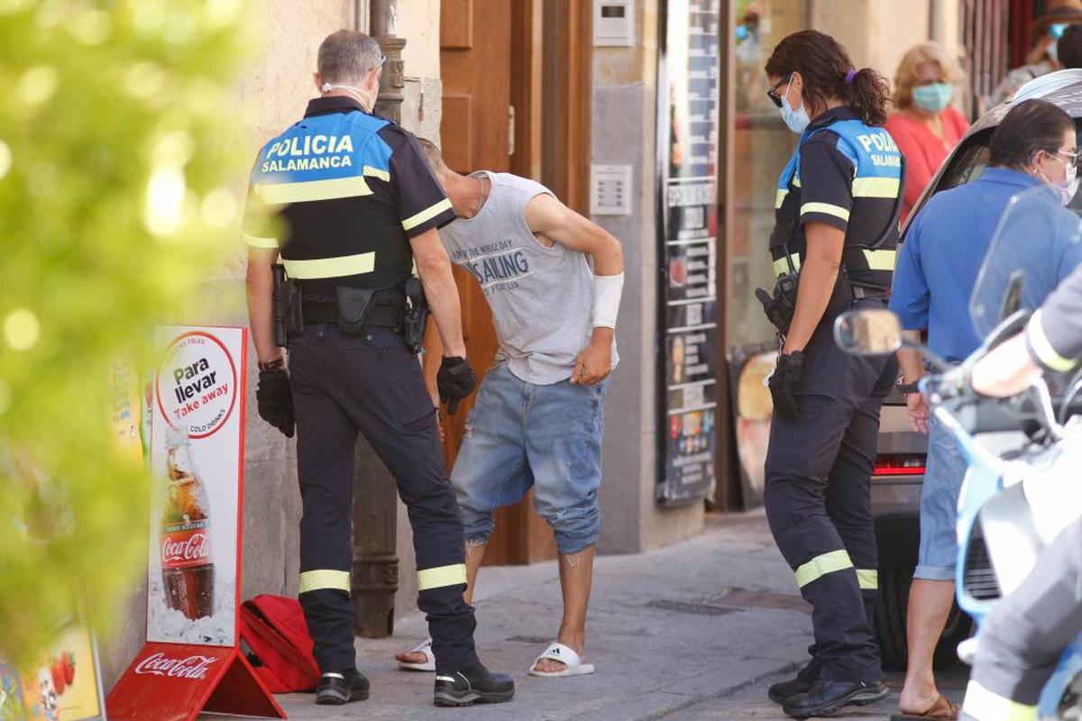 Agentes de la Policía registran a un sospechoso de hurtar mascarillas en un establecimiento de la Rúa.