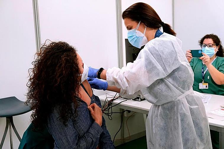 Empleada sanitaria suministrando vacuna