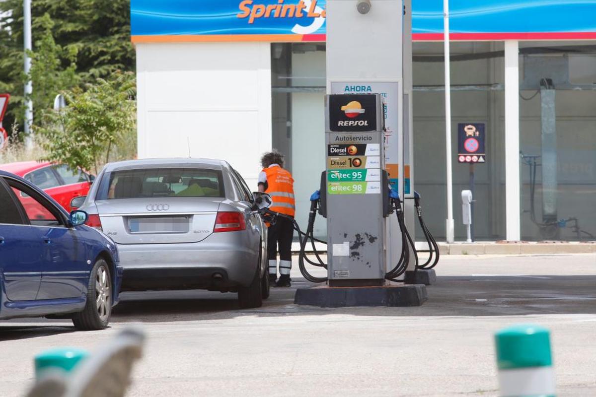 La empleada de una gasolinera repostando el coche de un cliente.