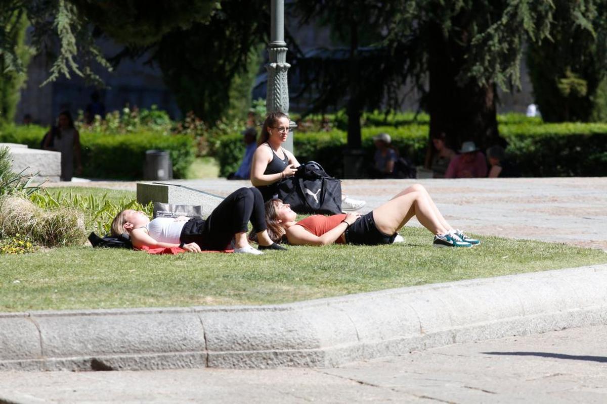 Varias personas toman el sol en la plaza de Anaya.