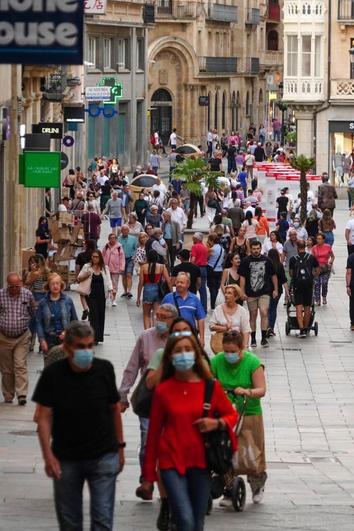 Viandantes con y sin mascarilla por el centro de Salamanca.