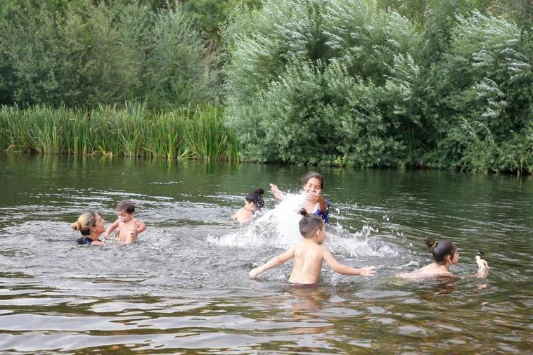 Un grupo de personas se refresca del calor asfixiante en el río.