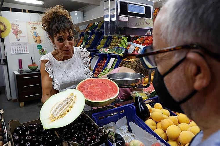 Una de las comerciantes del Mercado Central vendiendo melón y sandía a un cliente