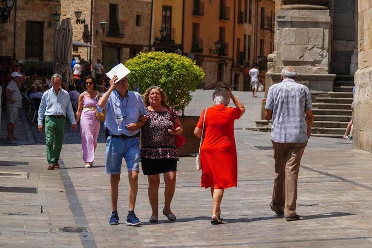 Viandantes pasean por el centro de Salamanca ayer a pleno sol.