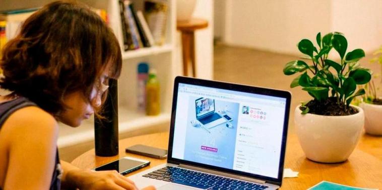 Una mujer realiza teletrabajo en su oficina casera.