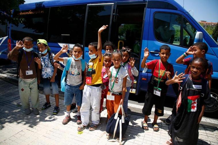 Los trece niños saludan a su llegada a la sede de Cruz Roja