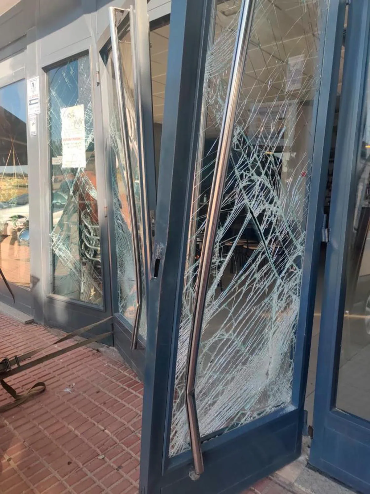 La puerta de entrada del restaurante, con daños ocasionados por los cacos.