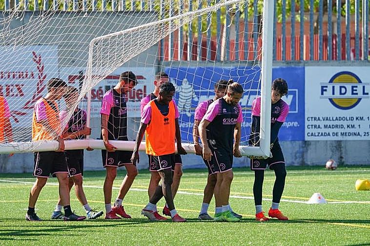 Alberto Sánchez (derecha) carga una portería junto a sus compañeros