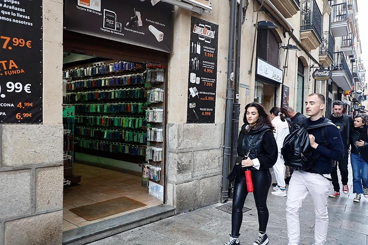 Una joven pasea junto a un establecimiento sin puerta, solo con trapa.