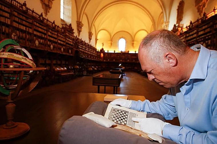 El bibliotecario Eduardo Hernández inspecciona el volumen del “Arte de ajedrez” en la Biblioteca de la Universidad.