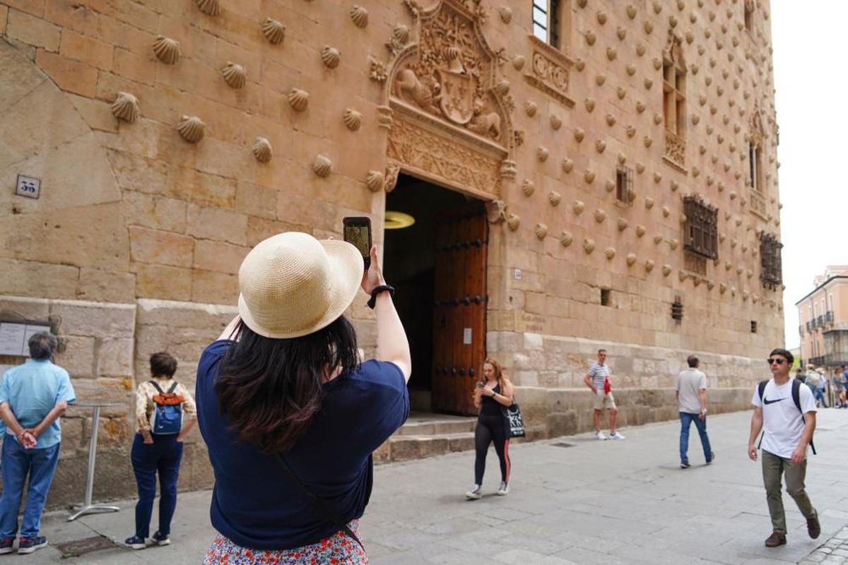 Una turista fotografía la casa de las Conchas