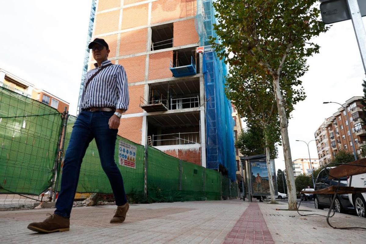 Un viandante pasa junto a un edificio de viviendas en construcción.