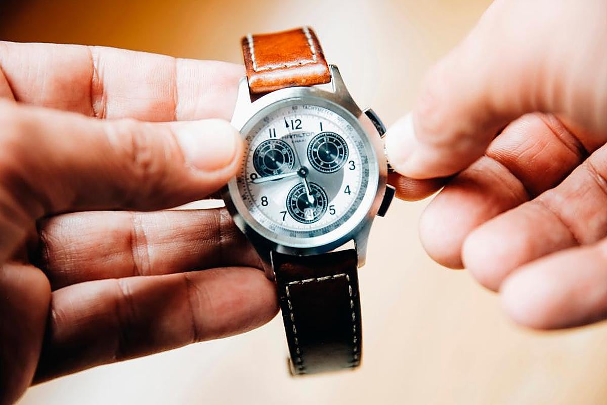 Una persona cambia la hora con las manecillas de reloj. E.P.