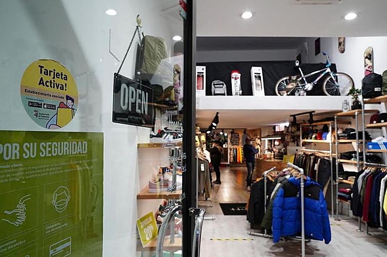 Puerta de acceso a un comercio de la ciudad con la pegatina de la Tarjeta Activa. LAYA