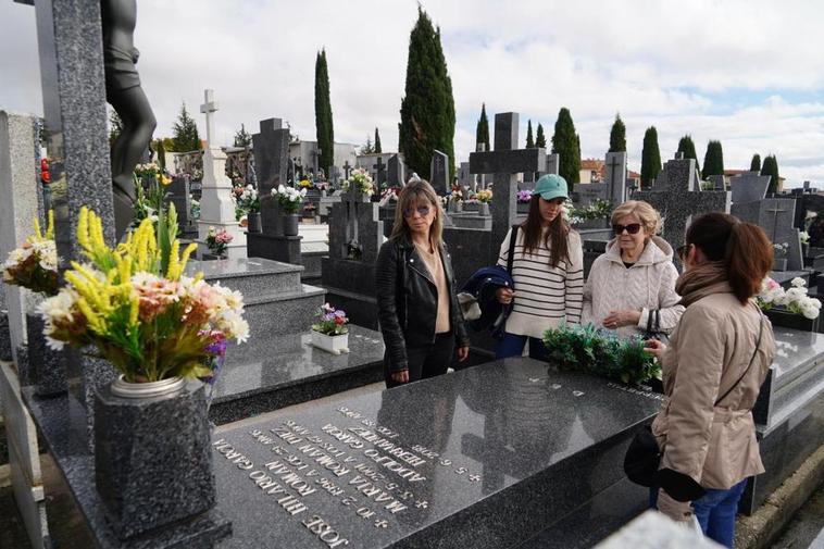 Una familia deposita sus flores en una de las tumbas del cementerio San Carlos Borromeo de Salamanca.