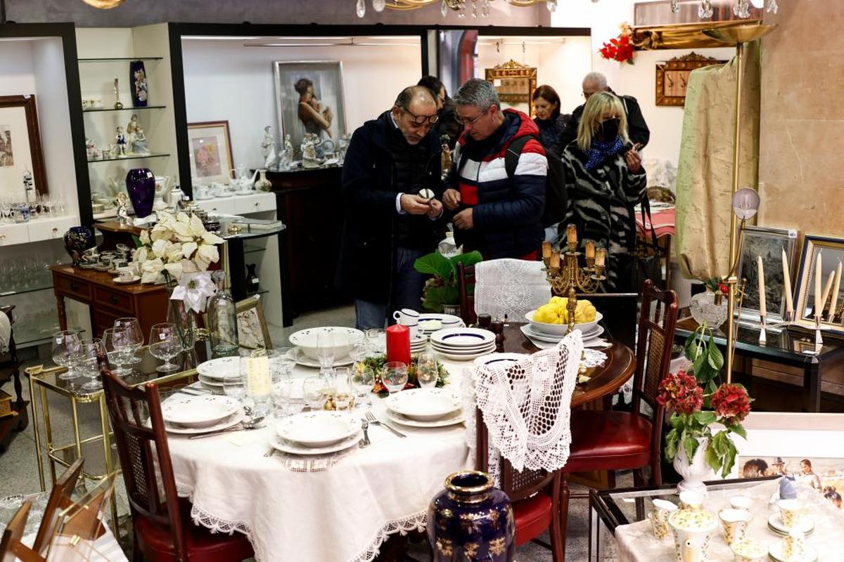 Varias personas observan los muebles, vajillas y objetos que se venden en el local de Azafranal