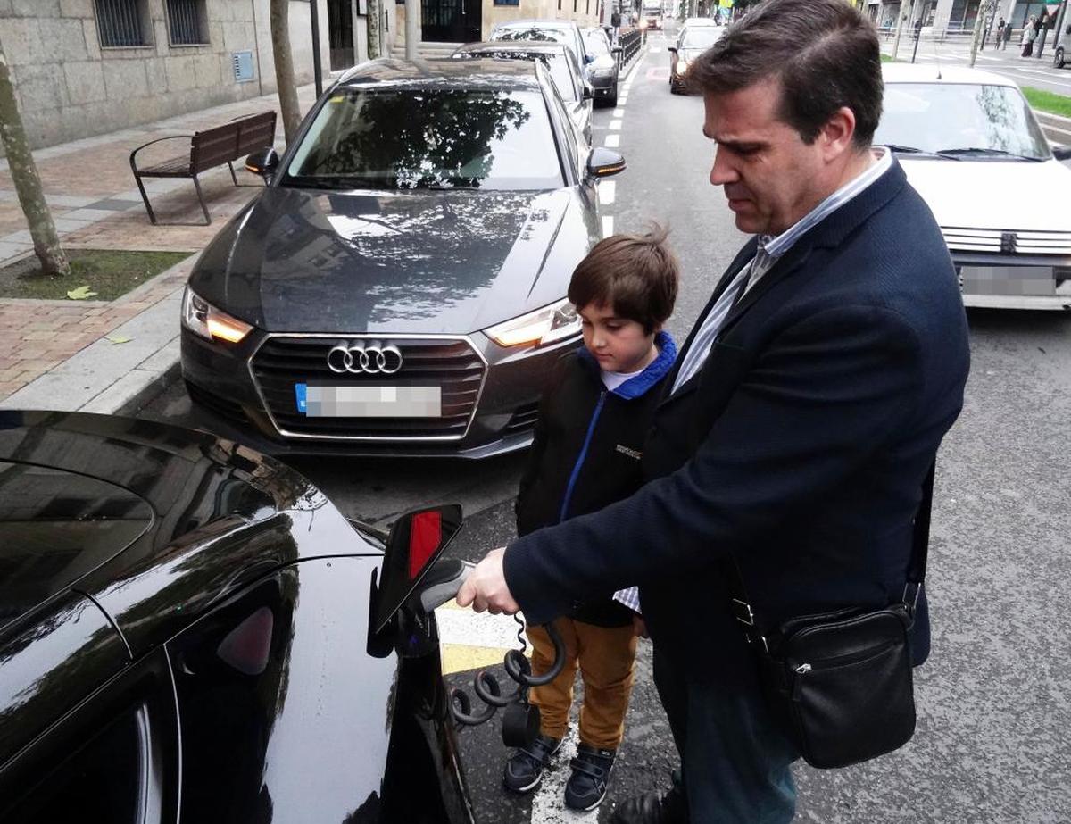 Roberto V. carga su vehículo eléctrico en el punto situado junto a la iglesia de María Auxiliadora.