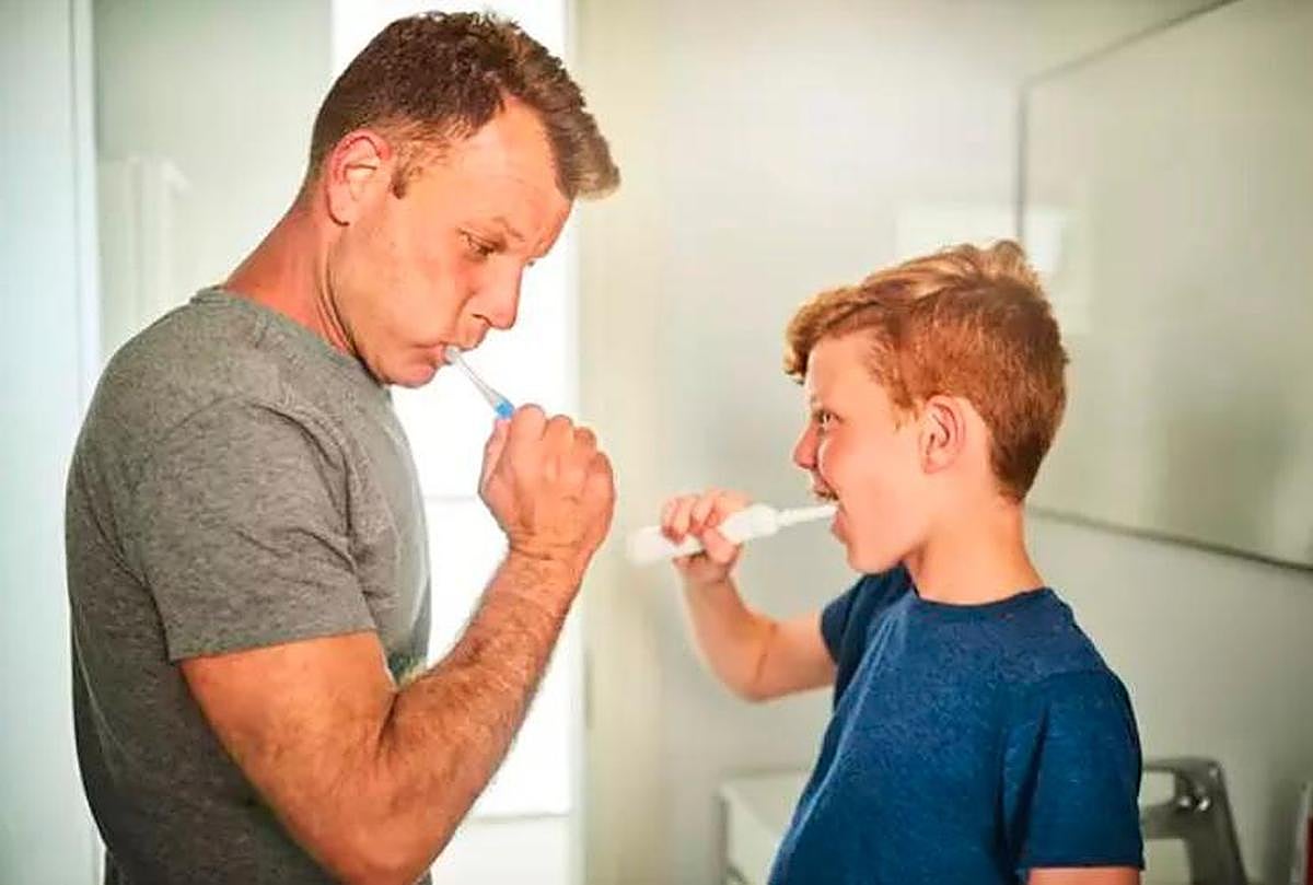 Un padre y un hijo lavándose los dientes