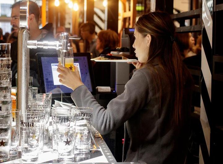 Una camarera sirviendo una cerveza.