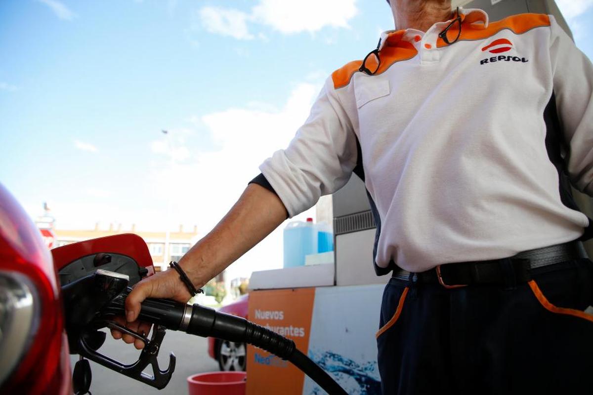 El trabajador de una gasolinera llena el depósito de un vehículo.