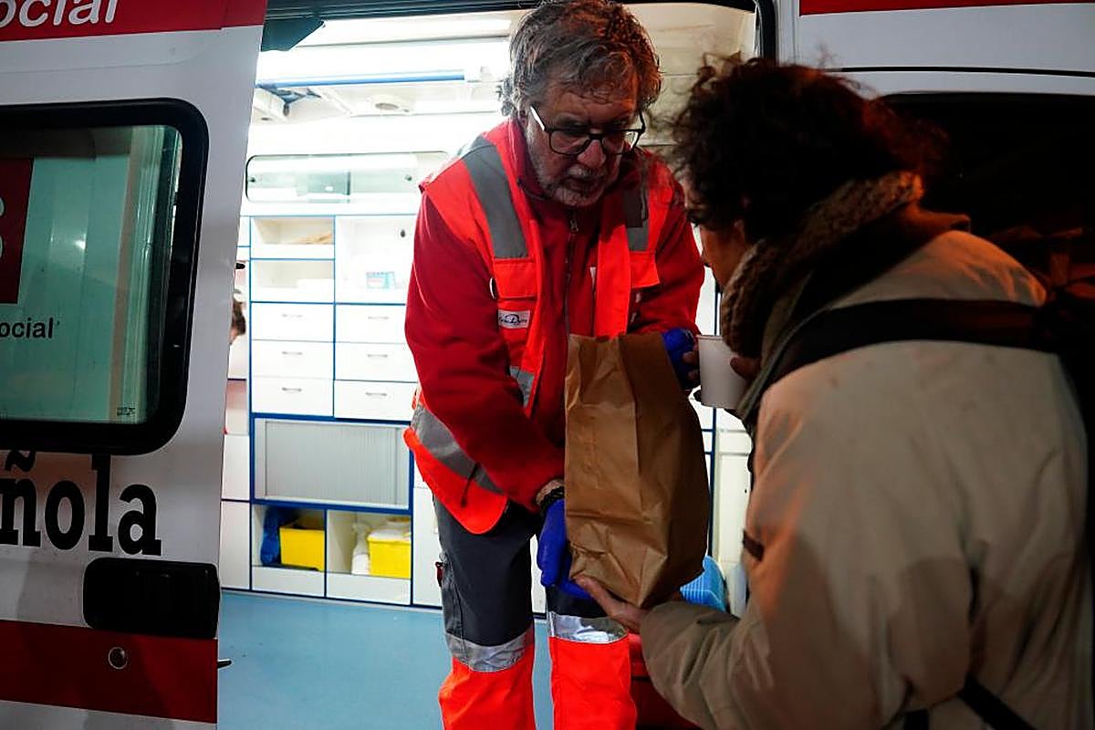 Darío entrega el menú navideño a una de las personas sin hogar que requería ayuda.