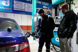 Un conductor y su acompañante llenan el depósito de su vehículo en una estación de servicio de Salamanca.